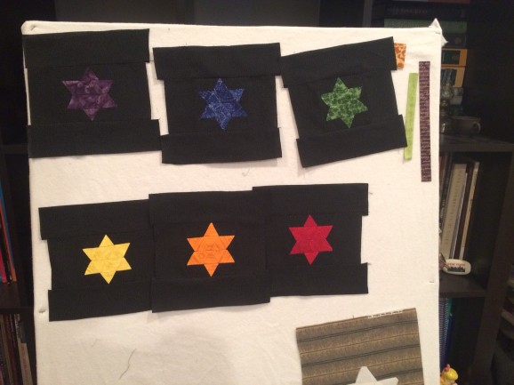 6 complete quilt tops attached to design board